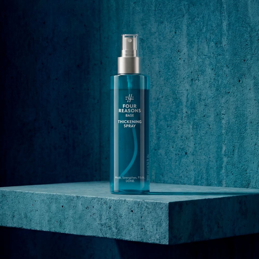 Four Reasons BASE Thickening Spray tuuheuttava tekstuurisuihke 200 ml pumppupullossa petrolinsinisessä kylpyhuoneessa.
